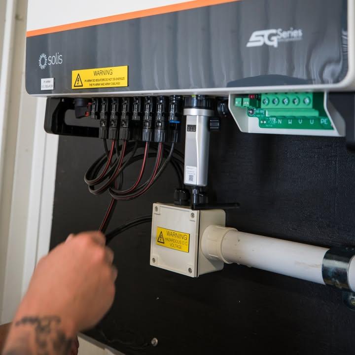 Electrician installing and hooking up the control panel for a solar panel array